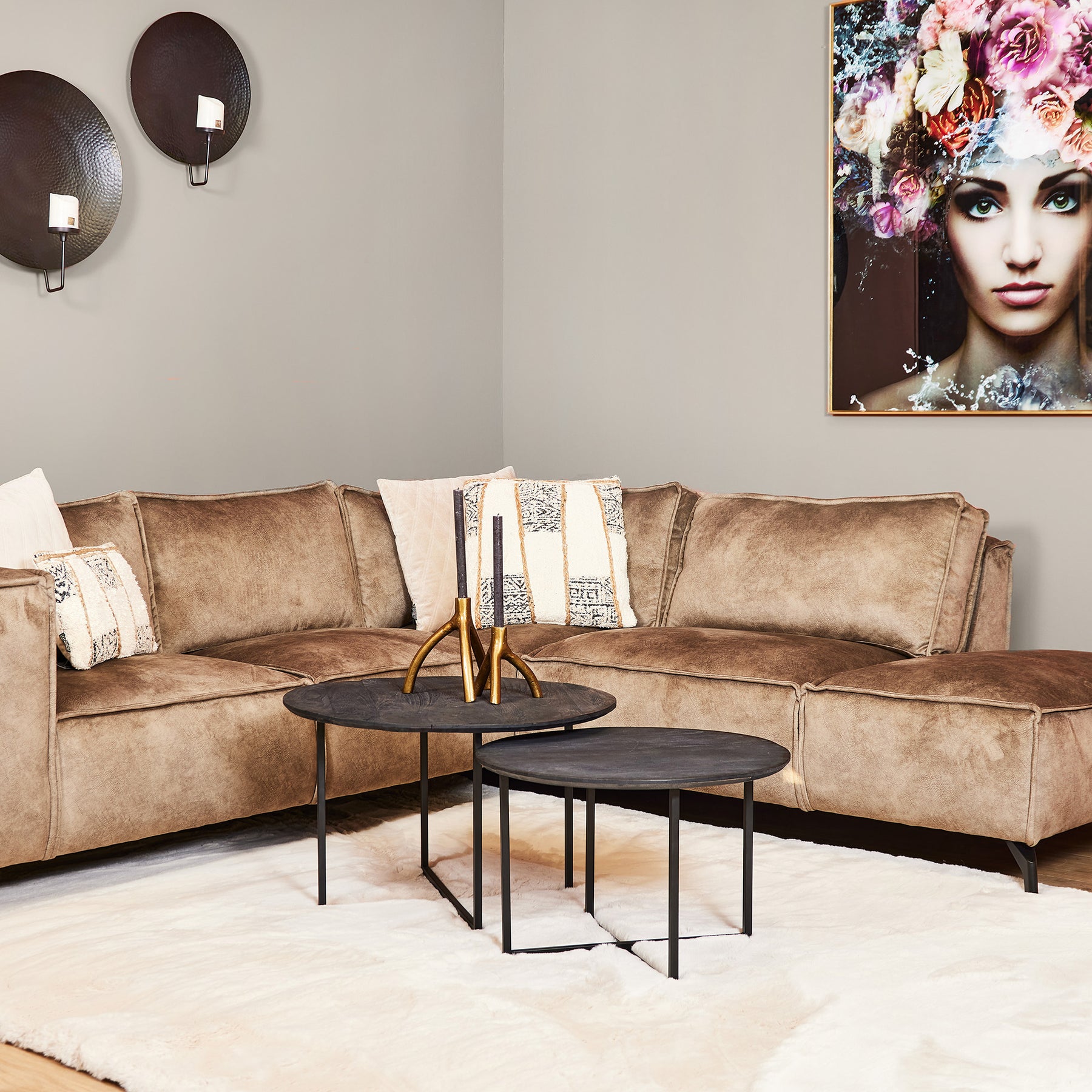 Bruine bank en set van 2 salontafels op een wit vloerkleed.
