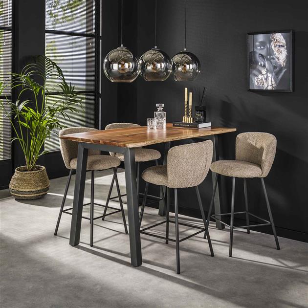 Moderne barkrukken van warm grijs stof en zwart metaal en een bartafel industrieel van mango houten zwarte metalen poten in een donker modern interieur.