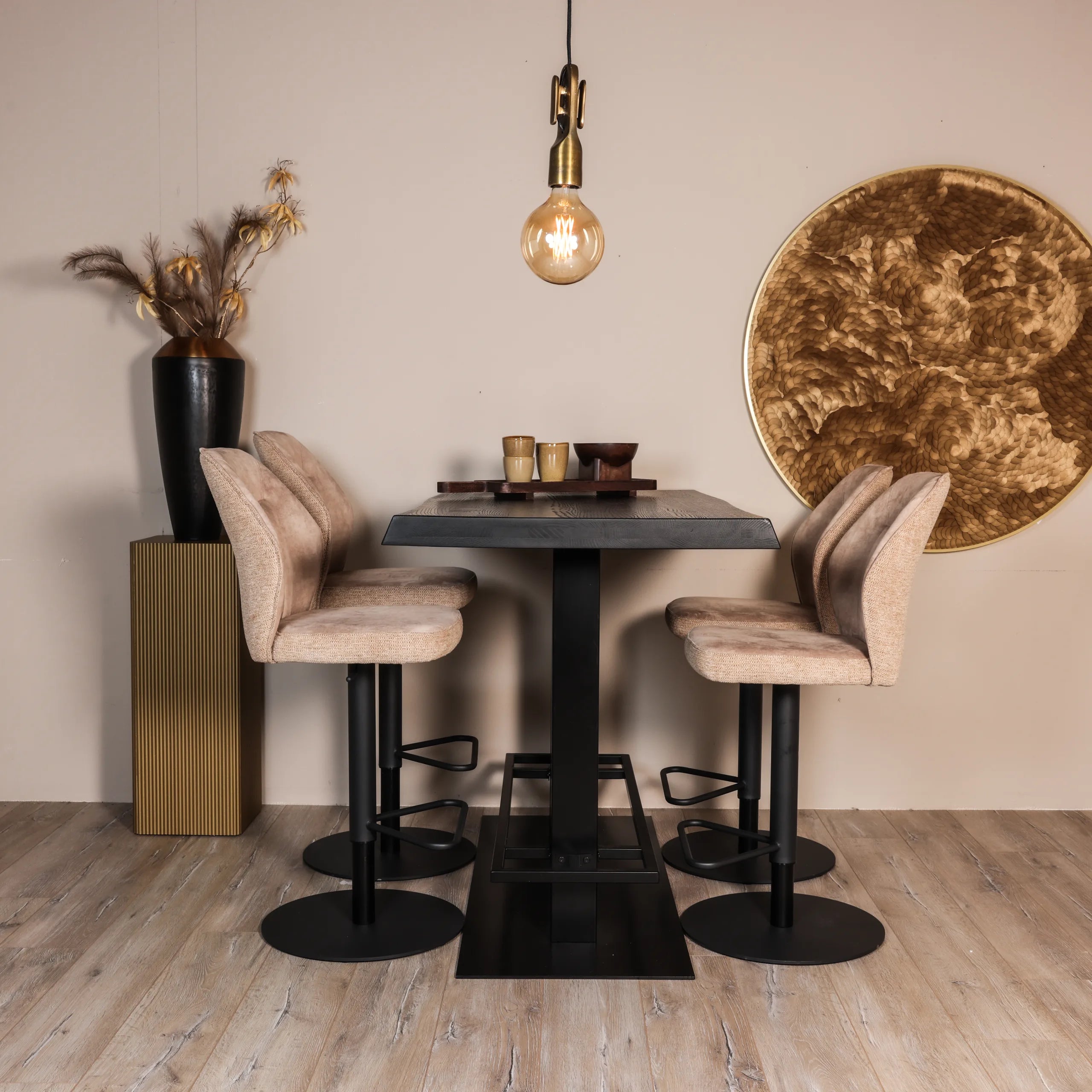 Warme moderne eetkamer met gouden decoraties en een zwarte bartafel industrieel met zachte roze barkrukken met zwart metalen poten.