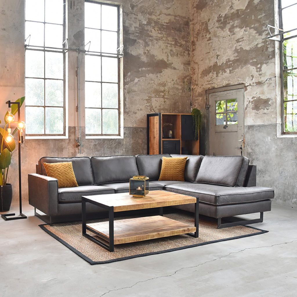 industriële woonkamer met grijze bank en salontafel van mango hout en zwart metaal.