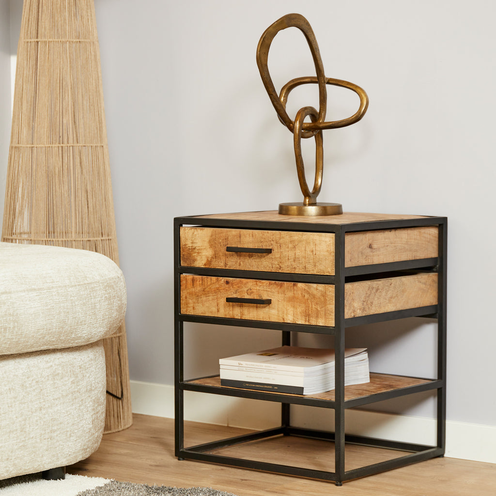 Vierkant bijzettafel van mango hout en zwart metaal met 2 lades en een open plank voor berging in een modern wit interieur.