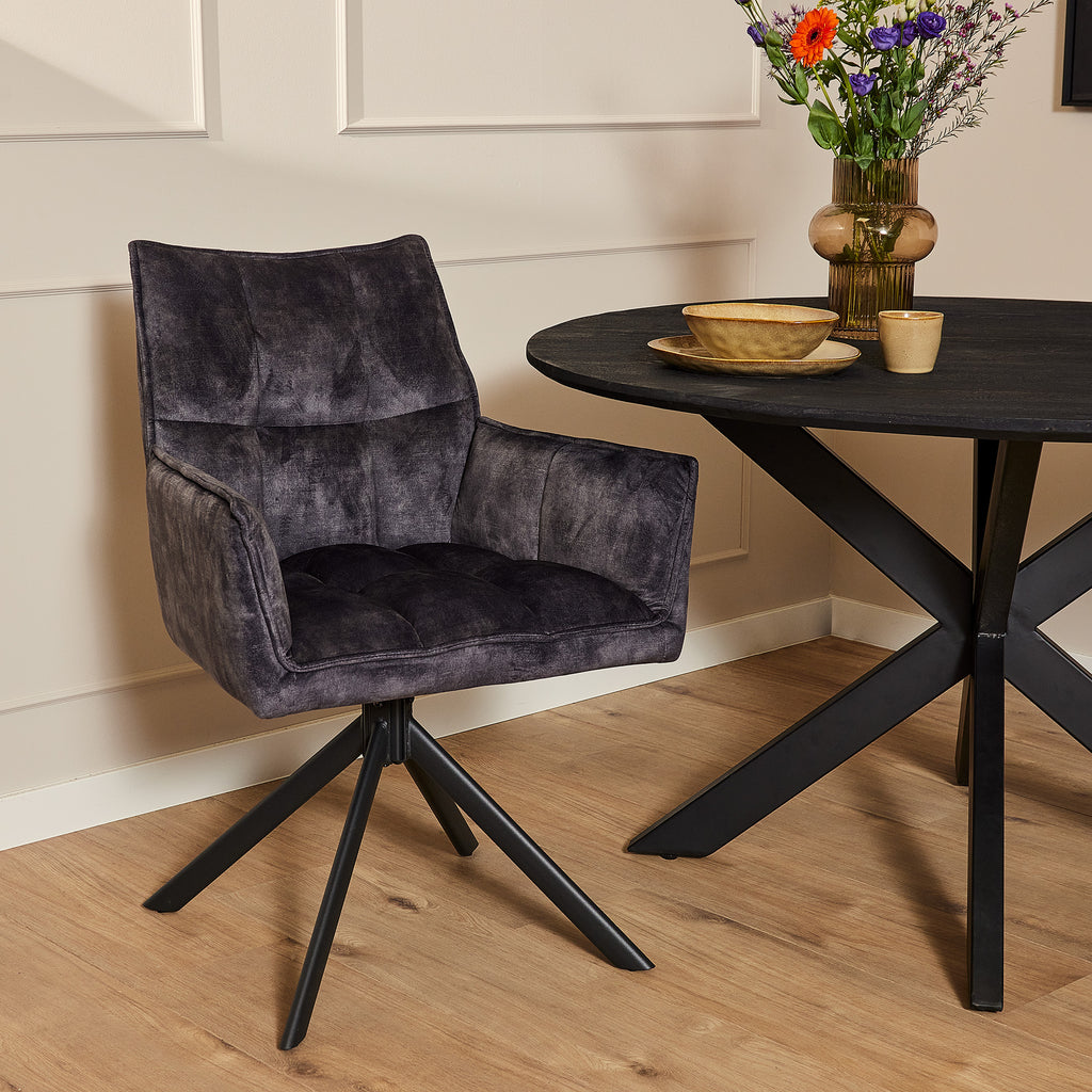 Velvet eetkamerstoel in een moderne eethoek met een zwarte eettafel.