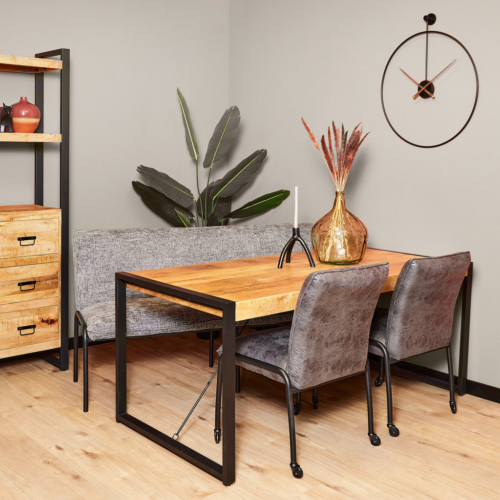 mangohouten eettafel met grijze eetkamerstoelen en eetkamerbank in een moderne eetkamer.