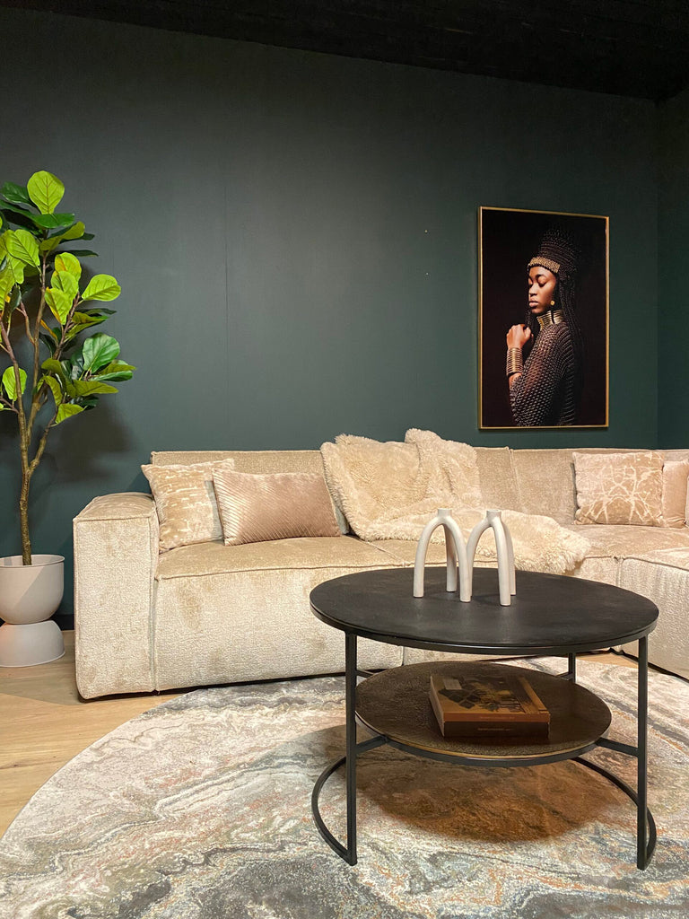 Velvet bank met zwarte metalen salontafel in een moderne woonkamer.