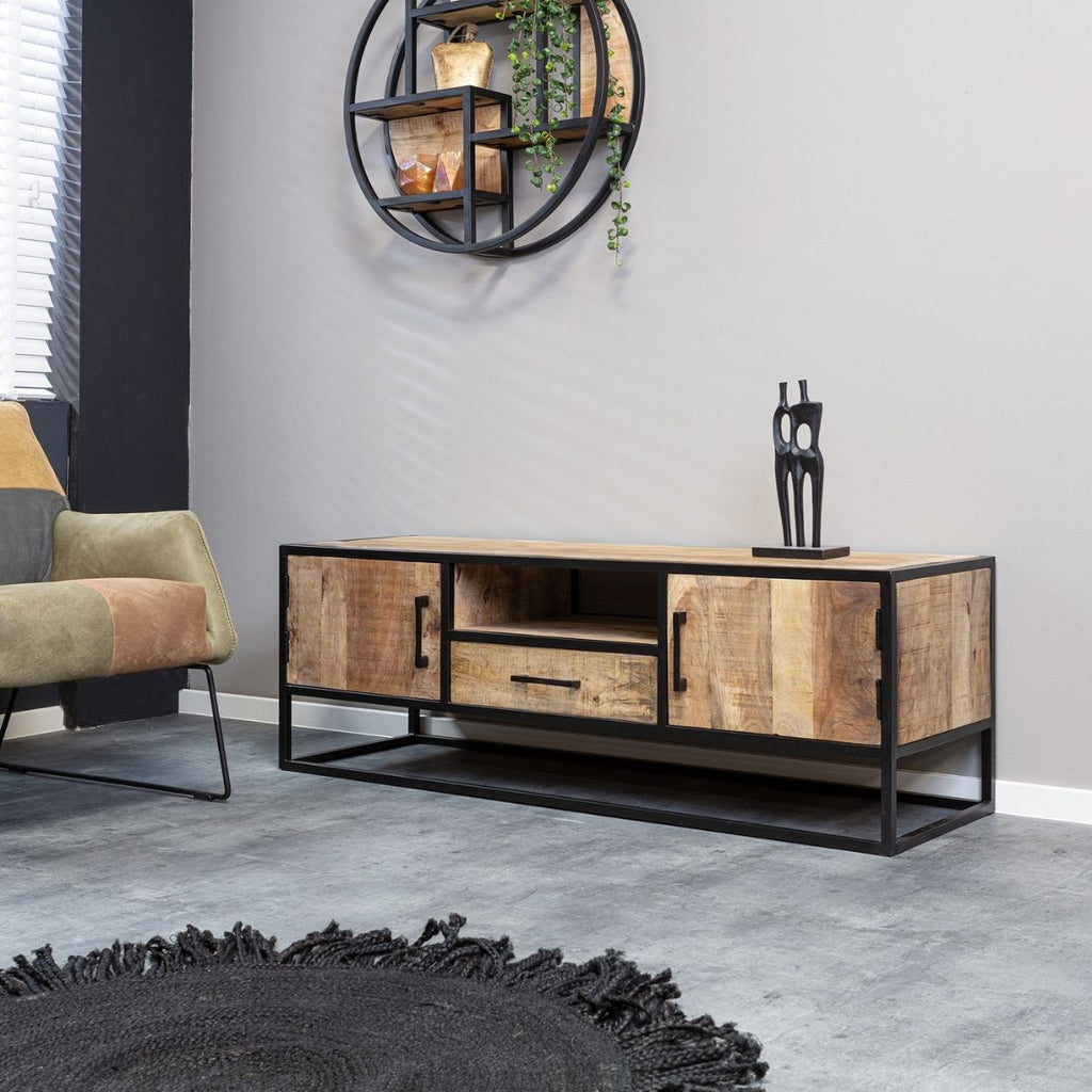 Moderne woonkamer met de focus op de mango hout tv-meubel met zwart metaal, de vloer en wand zijn grijs met een zwart vloerkleed voor het tv-meubel.