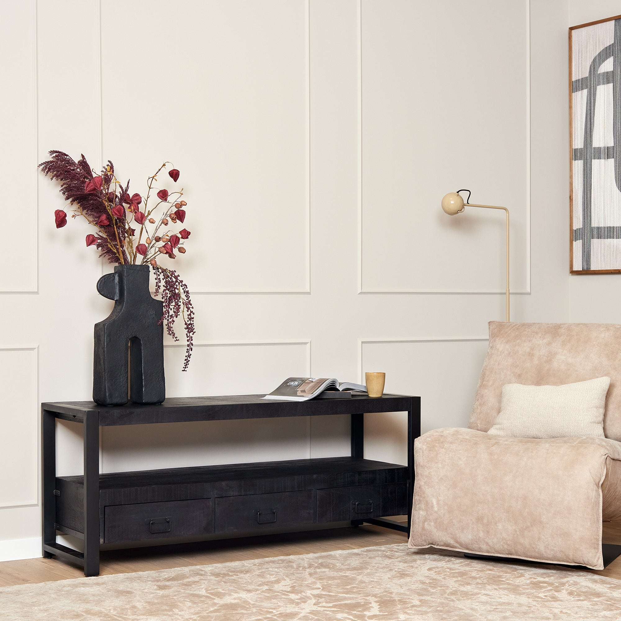 Sidetable van zwart mango hout en comfortabel fauteuil in beige. 