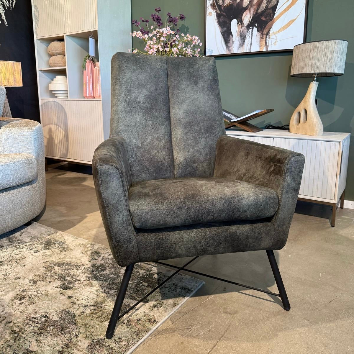 Grijs fauteuil in moderne showroom van De Friese Meubeljongens.