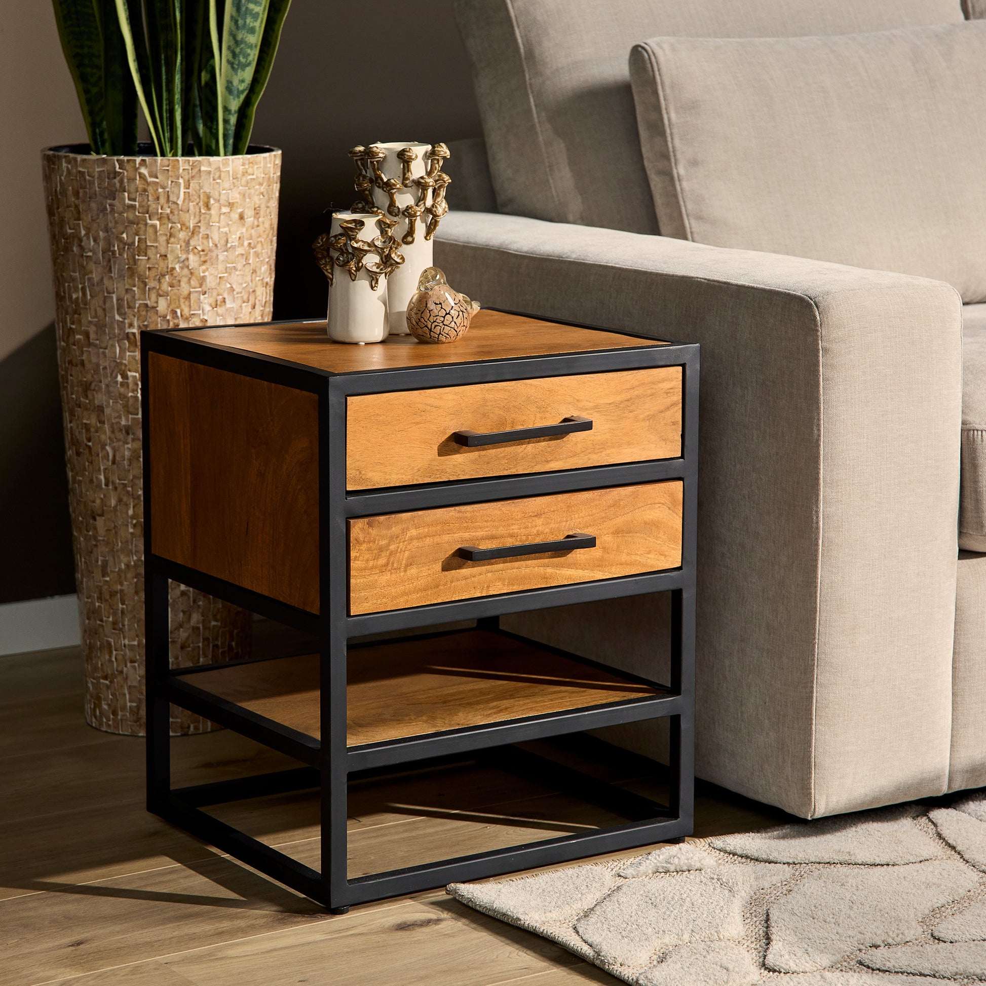 Sidetable industrieel in een moderne woonkamer naast een grijze bank.