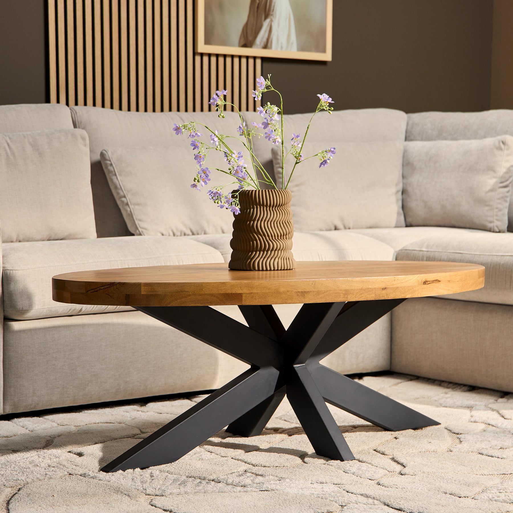Luxe Interieur Friesland salontafel van mangohout en zwart metalen poten in een moderne woonkamer met witte bank en bruine muren.