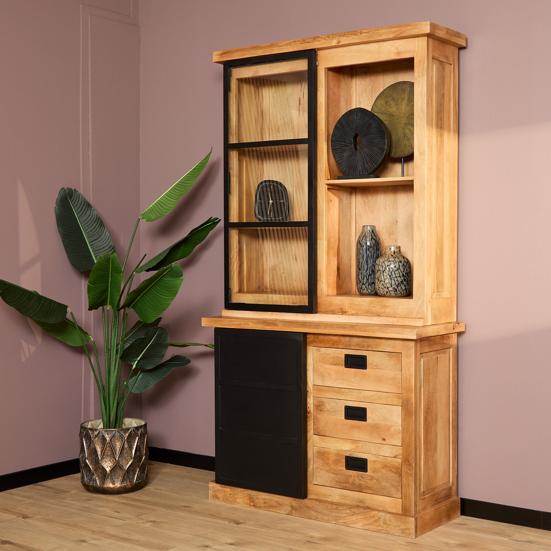 Vitrinekast van mangohout in een moderne roze woonkamer.