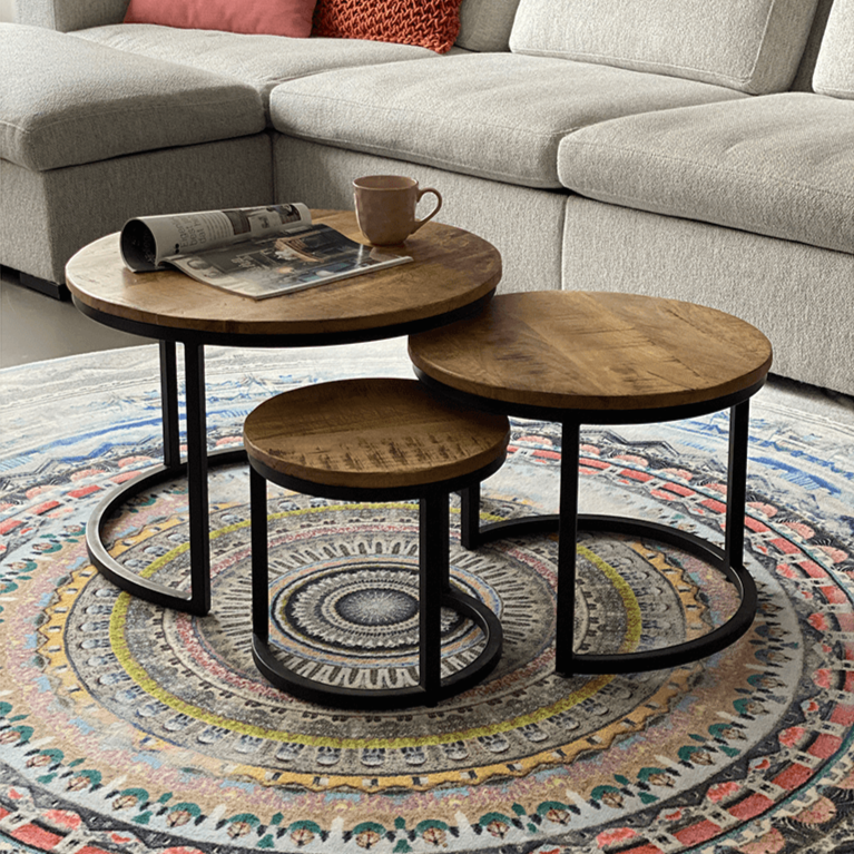 Salontafel set van 3 van mango hout en zwart metaal in een comfortabele woonkamer.