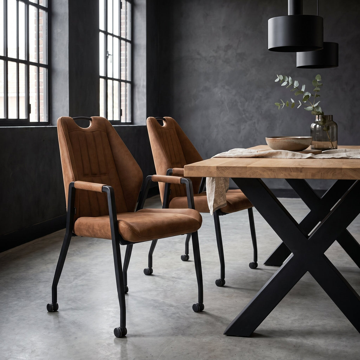 Eetkamerstoel Sara cognac met wieltjes aan eiken eettafel in industriële eetkamer