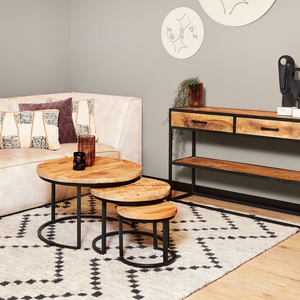 Salontafel set van 3 rond van mango hout en zwart metaal in een moderne woonkamer.