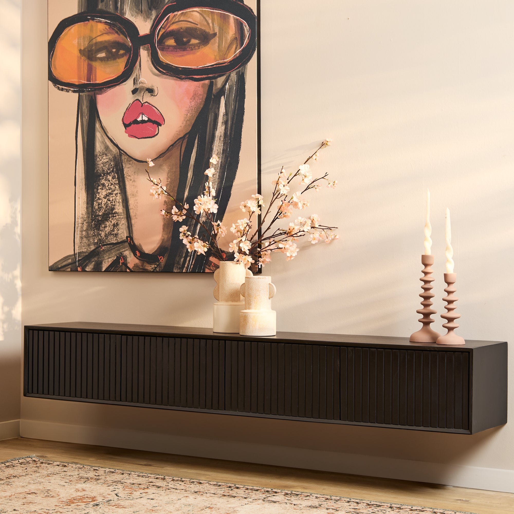 Moderne zwevende zwart metalen tv-meubel 140 cm in een moderne hall met sfeervolle roze decoraties.