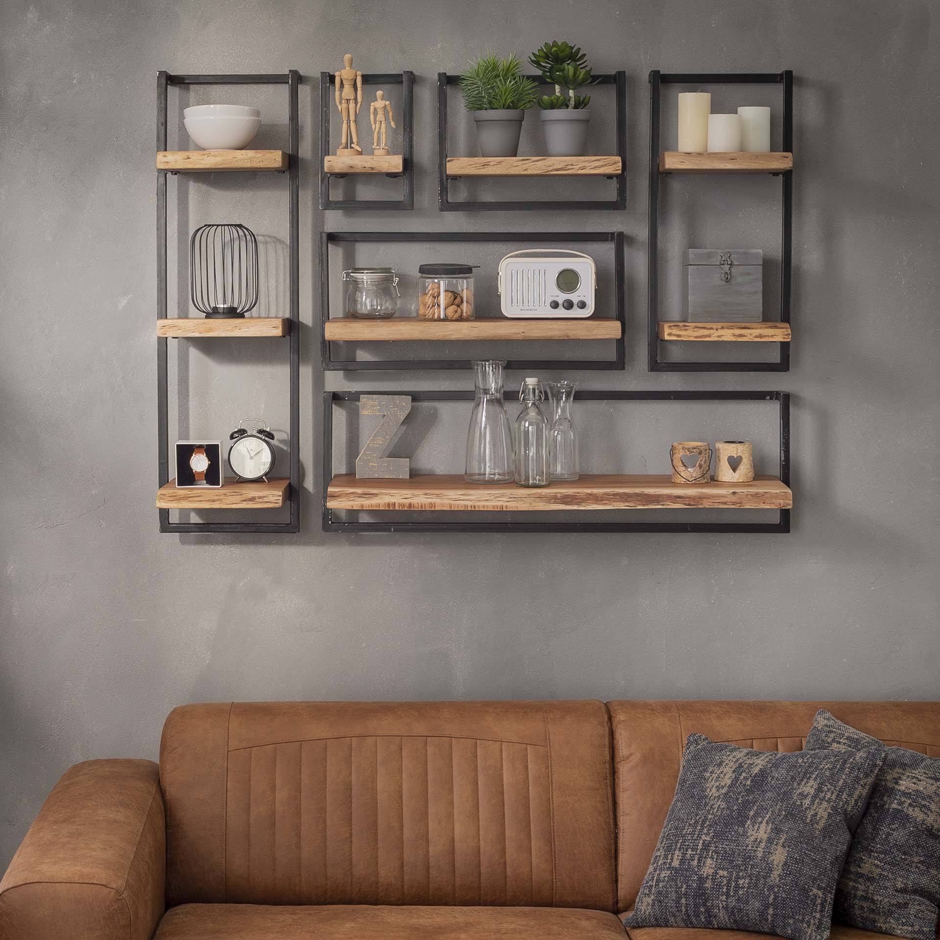 Wandplank hang rek van metaal industrieel op een beton look muur boven een leren bank.